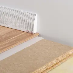 En vit ventilationsgaller för ett passivt ventilerat golv, med trägolv och byggmaterial.