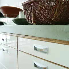 Köksbänk i betong, en stor flätad korg och skålar. En fin yta att behandla betongskiva på.