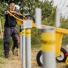 Man använder en stolpjärnmaskin för att slå ner stolpar. Perfekt för staketbygge, som en markskruv från Biltema.