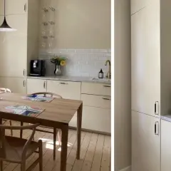 Ljust kök med träbord och stolar. Nya luckor ger ett fräscht intryck. Kaffemaskin och blommor på bänken.