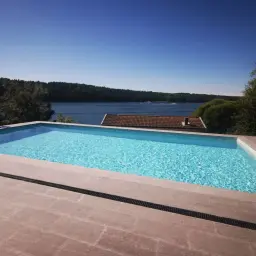 En lyxig pool med klarblått vatten och en fantastisk utsikt över en sjö. En dröm att bygga pool kostnad som är värd det.