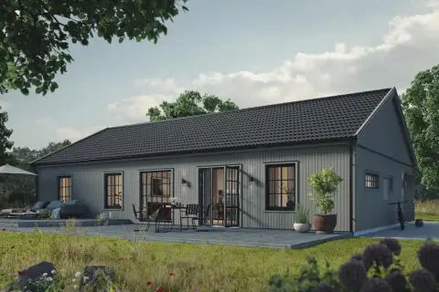 Grått trähus med altan och utemöbler. En cykel står parkerad. Tänk på vad kostar det att bygga ut huset för att få mer plats.