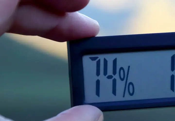 En digital hygrometer visar 74% luftfuktighet inomhus.